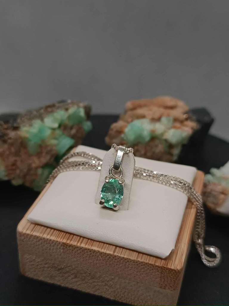 Emerald pendant displayed against velvet